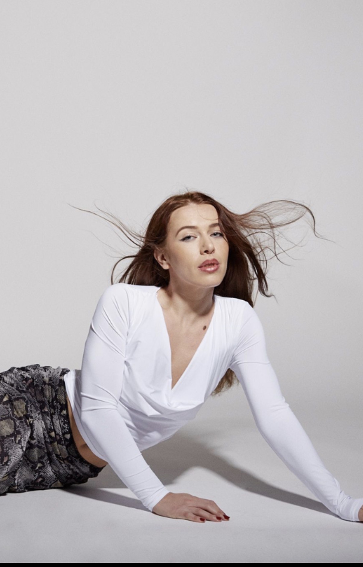 Edona Etemi wearing white, with flowing auburn hair
